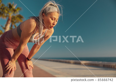 Strong lady resting by the coast after hard training 85888742