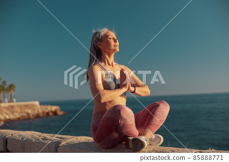 Strong slender lady resting by the waterfront Strong slender lady resting by the waterfront 85888771