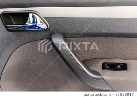Inside the passenger door of the car with the window lifter. Car door handle. Inside the passenger door of the car with the window lifter. Car door handle. 85888917