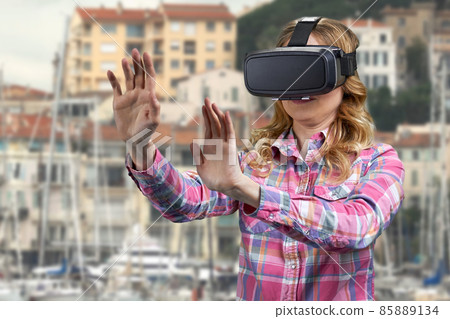 Girl wearing VR glasses on city buildings background. Girl wearing VR glasses on city buildings background. 85889134