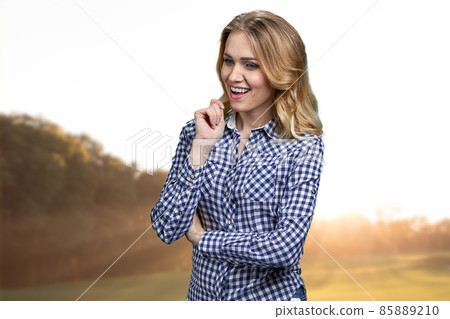 Pretty pensive girl with sly and cunning smile standing outdoors. 85889210