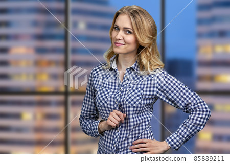 Pretty smiling business woman looking pensive. City night view from the office window. 85889211