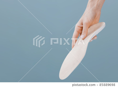 Orthopedic insole isolated on a blue background. Medical insoles. Treatment and prevention of flat feet and foot diseases. Foot care, feet comfort. Wear comfortable shoes. Flat Feet Correction. Orthopedic insole isolated on a blue background. Medical insoles. Treatment and prevention of flat feet and foot diseases. Foot care, feet comfort. Wear comfortable shoes. Flat Feet Correction. 85889698