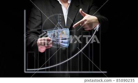 a businessman in a suit holds a pack of paper american dollars against the background of a holographic chart with growing indicators. The concept of high business profitability, income growth a businessman in a suit holds a pack of paper american dollars against the background of a holographic chart with growing indicators. The concept of high business profitability, income growth 85890235
