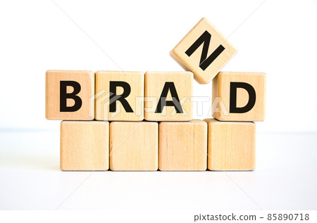 Brand symbol. The concept word 'brand' on wooden cubes on a beautiful white table, white background. Business and brand concept. Copy space. Brand symbol. The concept word 'brand' on wooden cubes on a beautiful white table, white background. Business and brand concept. Copy space. 85890718