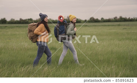 Happy girls travel with backpacks hiking, fun weekend outing with travel bags, active outdoor lifestyle, female group recreation, hipster travelers for thousands of years, free movement in search of 85891623