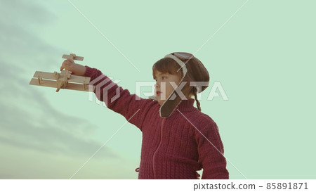 little child in a helmet plays with an airplane against sky, childhood dream to fly, kid wants to become an airplane pilot, imagination, happy family, cheerful baby makes illusion flight in fantasies little child in a helmet plays with an airplane against sky, childhood dream to fly, kid wants to become an airplane pilot, imagination, happy family, cheerful baby makes illusion flight in fantasies 85891871