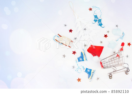 Trolley from a supermarket with New Year's gifts and New Year's toys on a light background.Flat lay, top view, wide banner.Christmas and New Year background. Trolley from a supermarket with New Year's gifts and New Year's toys on a light background.Flat lay, top view, wide banner.Christmas and New Year background. 85892110