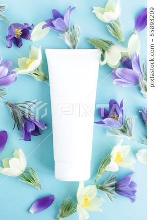 Cosmetics various jars and bottles on background of fresh spring purple flowers. Beauty concept, face body skin care spa 85893209