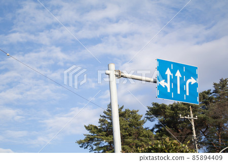 Arrow sign at the fork in the cloudy sky and at the intersection Arrow sign at the fork in the cloudy sky and at the intersection 85894409