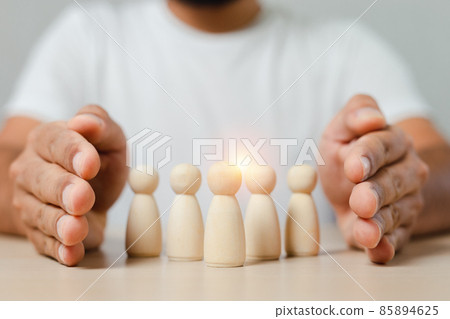 Man hands are encircle group of wooden puppet with leadership corporate of teamwork. 85894625