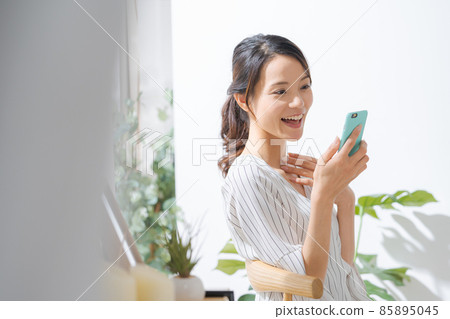 30 多歲女性在室內使用智能手機 85895045