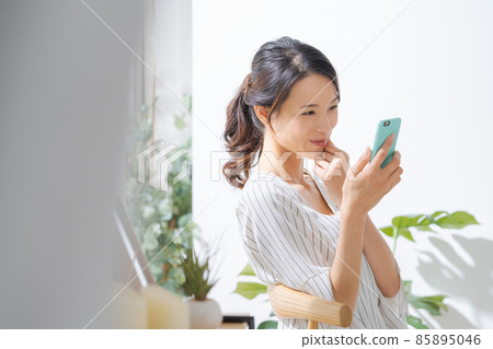 30 多歲女性在室內使用智能手機 85895046