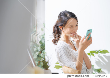 30 多歲女性在室內使用智能手機 85895047