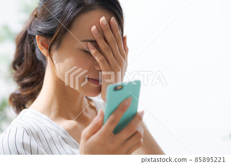 Female in her 30s smartphone indoors 85895221