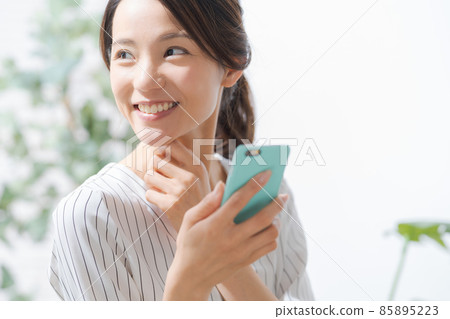 30 多歲女性在室內使用智能手機 30 多歲女性在室內使用智能手機 85895223