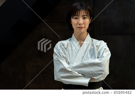 A woman wearing a dogi and folding her arms A woman wearing a dogi and folding her arms 85895482