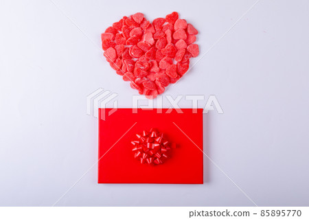 Red heart shape candies over gift box around copy space on white background Red heart shape candies over gift box around copy space on white background 85895770