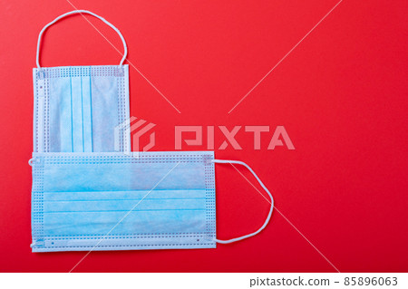 Overhead view of protective face masks arranged in heart shape over red background, copy space Overhead view of protective face masks arranged in heart shape over red background, copy space 85896063