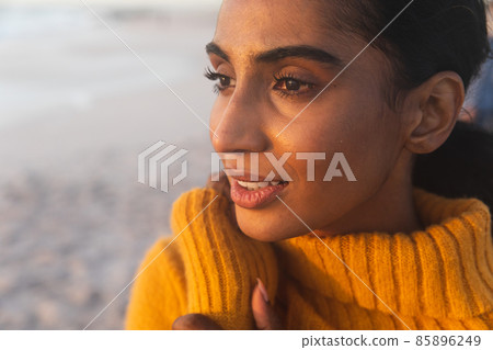 Close-up of young biracial woman thinking while looking away at beach during sunset Close-up of young biracial woman thinking while looking away at beach during sunset 85896249