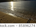 The warmth of the setting sun reflected on the surface of the water 85896274