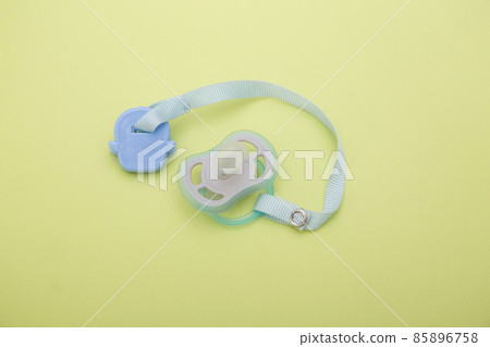 Blue baby pacifier isolated on green  85896758