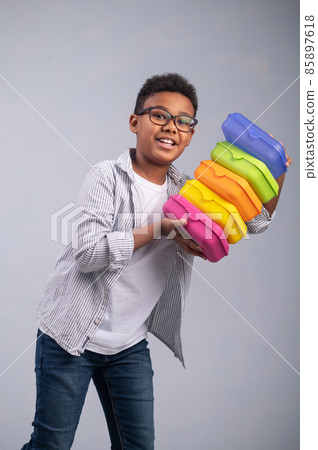 Kid posing for the camera with food containers Kid posing for the camera with food containers 85897618