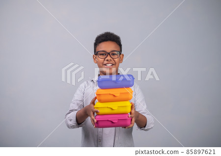 Smiling pupil demonstrating colorful plastic food containers Smiling pupil demonstrating colorful plastic food containers 85897621