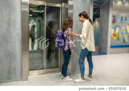 Joyful woman and a kid waiting for the passenger lift 85897630