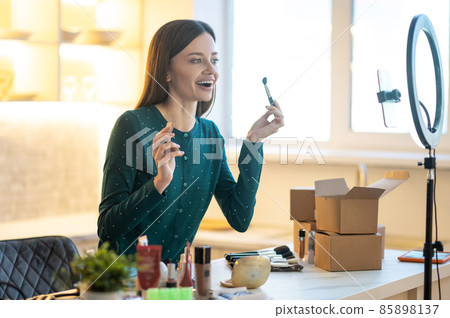 Young woman in green dress showing make up tips online Young woman in green dress showing make up tips online 85898137