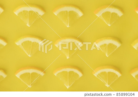 Fan-shaped slices of lemon lined up all over 85899104