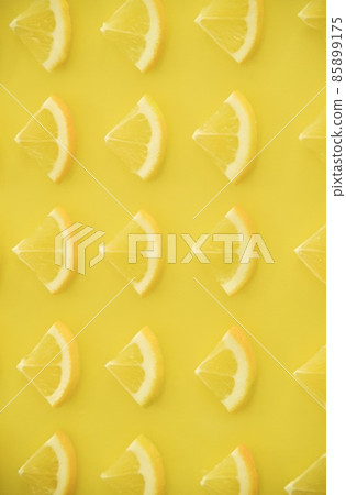 Fan-shaped slices of lemon lined up on one side Vertical composition 85899175