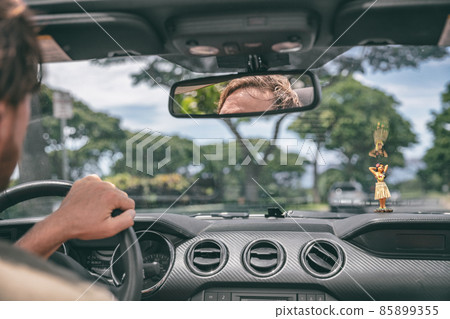 Car road trip summer travel vacation man driving sports convertible open rooftop cabriolet. View of windshield with hula doll on dashboard 85899355