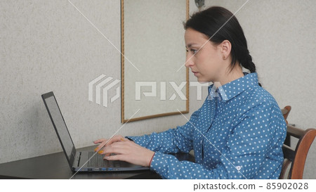 A business woman works at a computer in the office, a freelancer types text on the keyboard, online in a program remotely, the Internet for data transfer, a girl fills in and maintains important A business woman works at a computer in the office, a freelancer types text on the keyboard, online in a program remotely, the Internet for data transfer, a girl fills in and maintains important 85902028