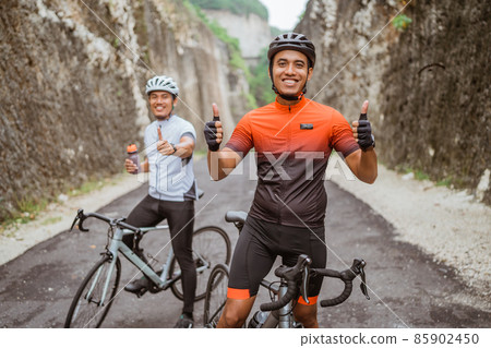 asian cyclist showing thumb up and smile to camera asian cyclist showing thumb up and smile to camera 85902450