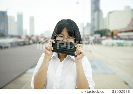 asian teenager with protection face mask in hand standing outdoor asian teenager with protection face mask in hand standing outdoor 85902928