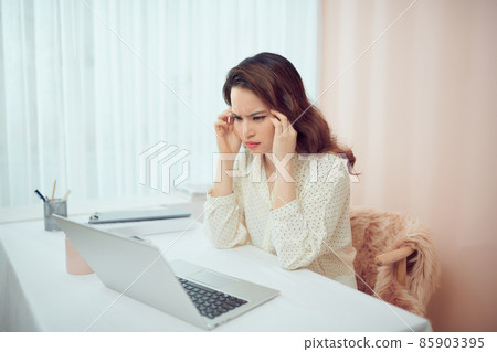 Overworked tired Asian female student worker massaging eyes Overworked tired Asian female student worker massaging eyes 85903395