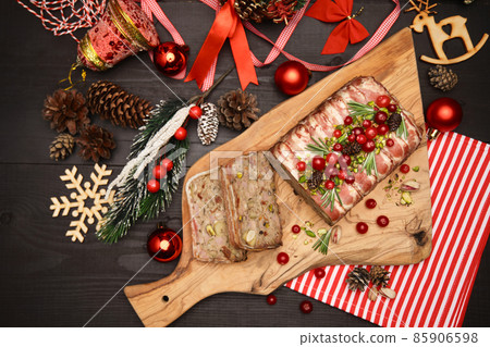 Traditional French terrine covered with bacon on dark wooden background with Christmas decorations Traditional French terrine covered with bacon on dark wooden background with Christmas decorations 85906598