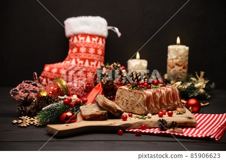 Traditional French terrine covered with bacon on dark wooden background with Christmas decorations Traditional French terrine covered with bacon on dark wooden background with Christmas decorations 85906623