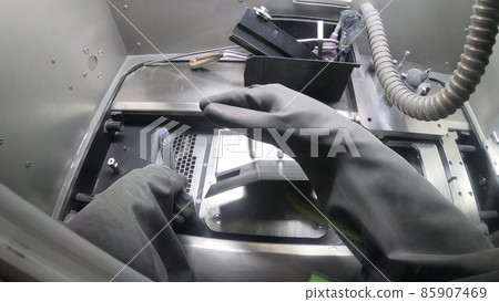 Male worker in rubber glove cleans printing platform inside 3d printer for metal Male worker in rubber glove cleans printing platform inside 3d printer for metal 85907469