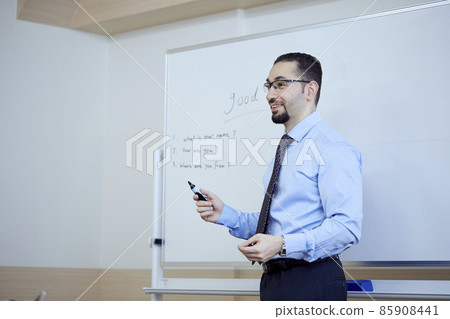 Male teacher teaching English in an English conversation class 85908441