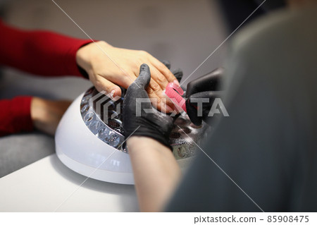Nail master cleaning clients hands from dust with special brush Nail master cleaning clients hands from dust with special brush 85908475