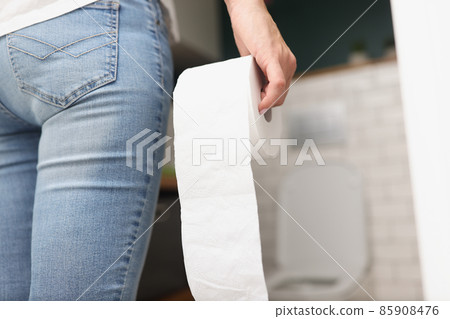 Woman hold white clean toilet paper roll in hands, enter toilet room Woman hold white clean toilet paper roll in hands, enter toilet room 85908476