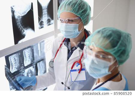 Women professional doctors look through x ray scans in hospital, examine patients result 85908520