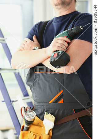 Professional carpenter man in uniform with electric drill, ready to start renovation Professional carpenter man in uniform with electric drill, ready to start renovation 85908544