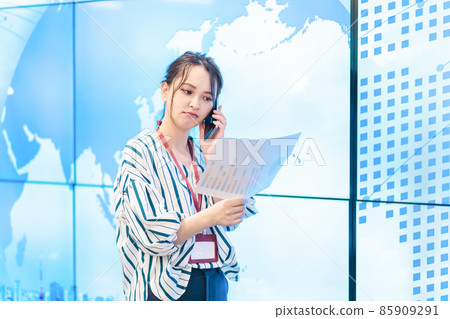 Business woman standing in front of a large display 85909291