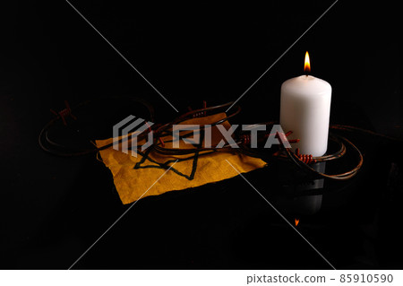 Holocaust memory day. Arbed wire and burning candle on black background 85910590