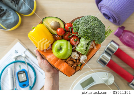 Healthy lifestyle on ketogenic diet, eating clean keto food good health dietary in heart dish with aerobic body exercise, gym workout training class , weight scale and sports shoes in fitness center 85911391