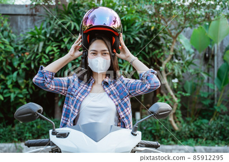 Woman with mask wearing helmet before road riding motorbike 85912295