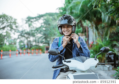 Man getting ready to wear helmet before going on motorbike 85912391
